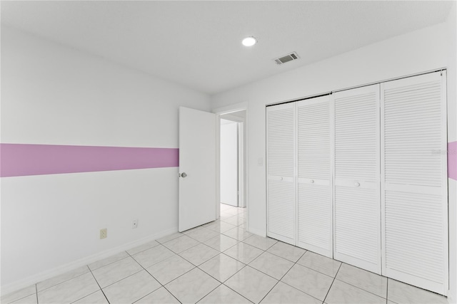 unfurnished bedroom featuring a closet and light tile patterned floors