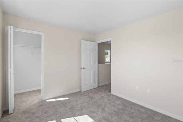 unfurnished bedroom with a closet and light colored carpet