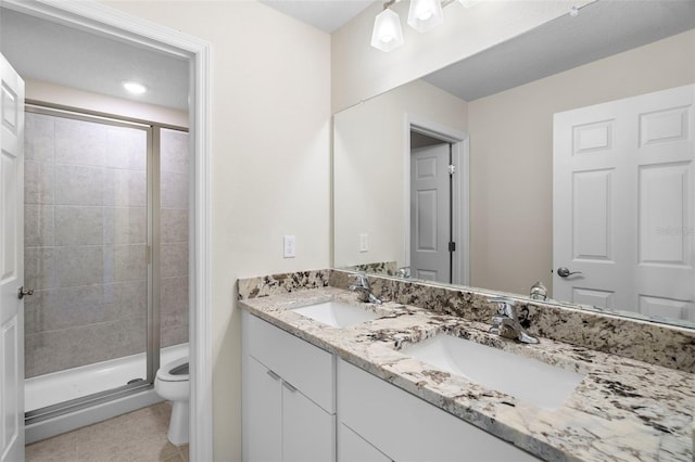 bathroom featuring toilet, walk in shower, vanity, and tile patterned floors