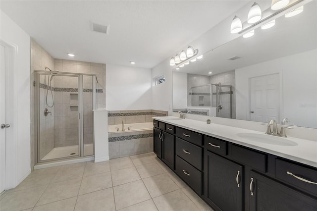 full bath with double vanity, a stall shower, a sink, tile patterned flooring, and a bath