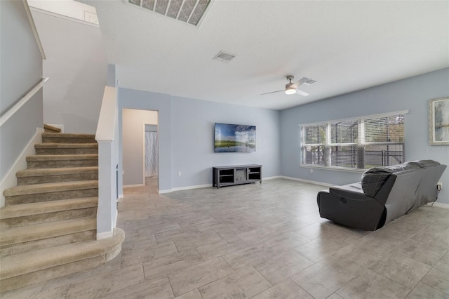 living room with stairway, visible vents, and a ceiling fan