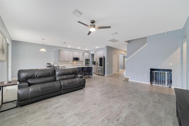 living area with ceiling fan, recessed lighting, visible vents, and baseboards