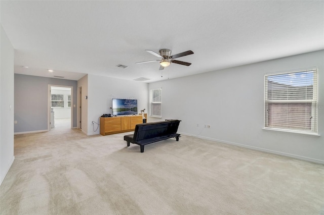 living area featuring light carpet, baseboards, visible vents, and ceiling fan