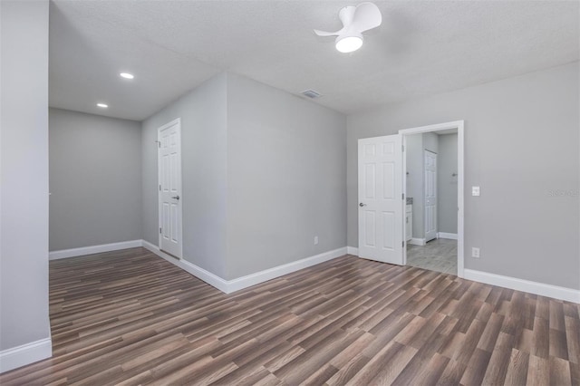 empty room with a textured ceiling and dark hardwood / wood-style floors