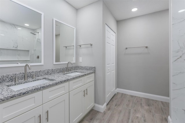 bathroom featuring tiled shower, wood-type flooring, and vanity