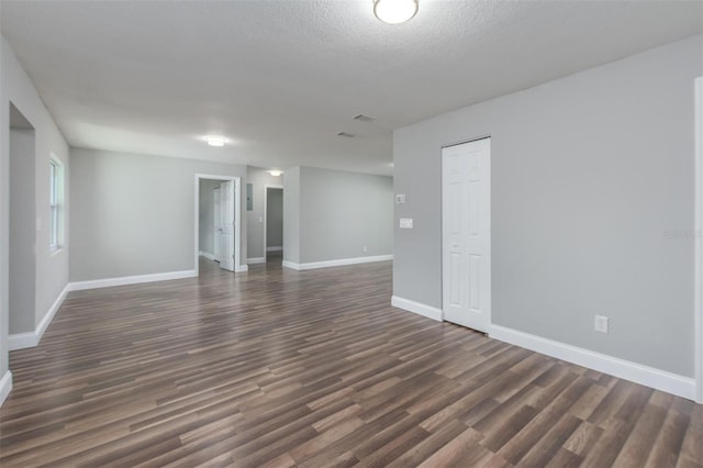 unfurnished room featuring a textured ceiling and dark wood-type flooring