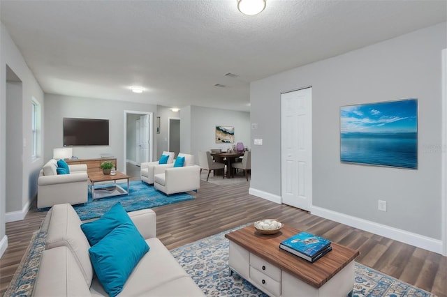 living room with dark hardwood / wood-style flooring and a textured ceiling