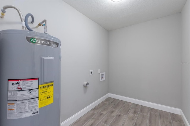 laundry room with a textured ceiling, light wood-type flooring, electric dryer hookup, and water heater