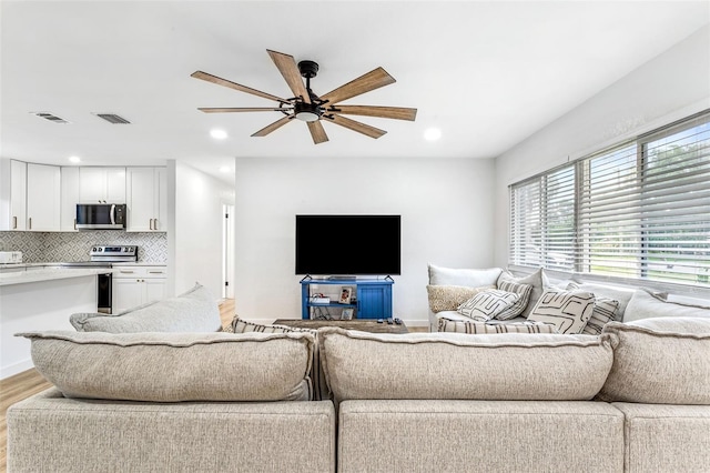 living room featuring light wood-type flooring and ceiling fan