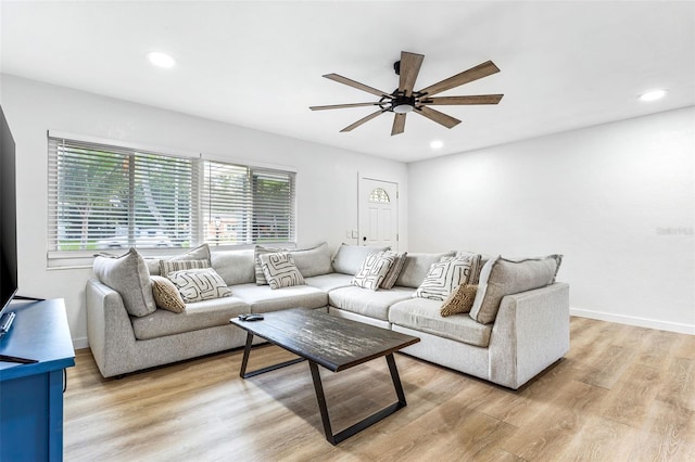 living room with ceiling fan, light wood-type flooring, and plenty of natural light