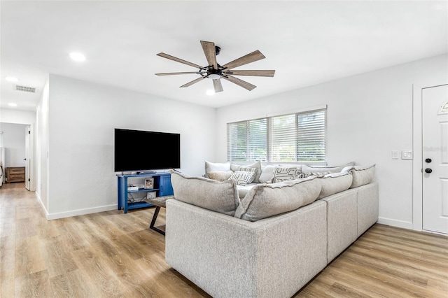 living room with wood-type flooring and ceiling fan