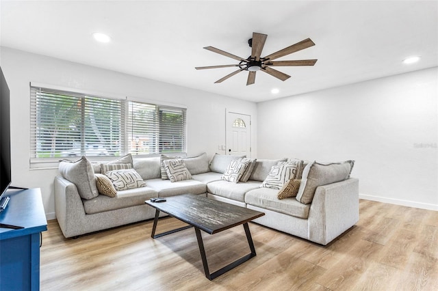 living room with light hardwood / wood-style floors and ceiling fan