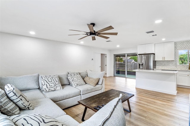 living room with light hardwood / wood-style flooring and ceiling fan