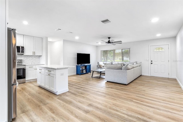 living room with ceiling fan and light wood-type flooring