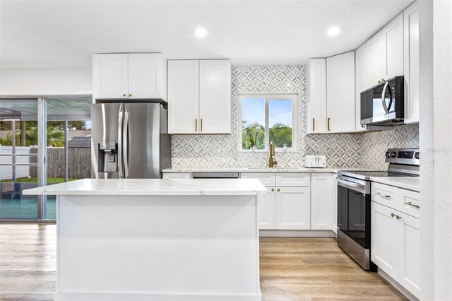 kitchen featuring appliances with stainless steel finishes, light wood-type flooring, and white cabinets