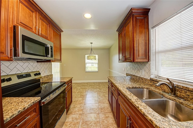 kitchen featuring appliances with stainless steel finishes, backsplash, sink, light tile patterned floors, and pendant lighting