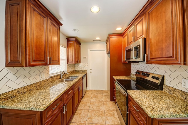 kitchen featuring sink, stainless steel appliances, light stone counters, decorative backsplash, and light tile patterned floors