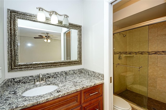 bathroom featuring walk in shower, ceiling fan, vanity, and toilet