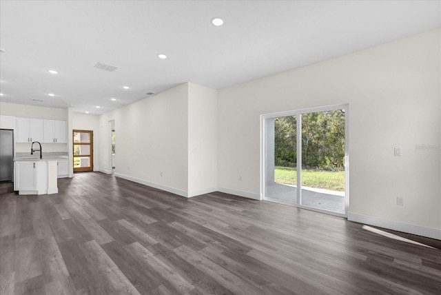 unfurnished living room with sink and dark hardwood / wood-style floors