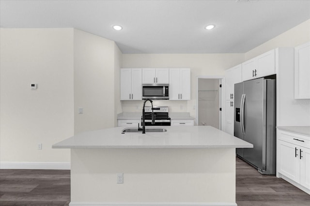 kitchen featuring white cabinets, dark wood-type flooring, a kitchen island with sink, and appliances with stainless steel finishes