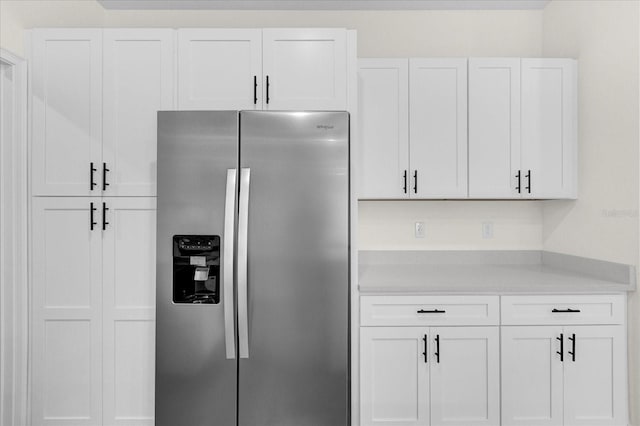 kitchen featuring stainless steel refrigerator with ice dispenser and white cabinets