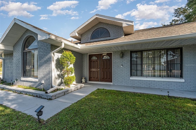 property entrance with a lawn