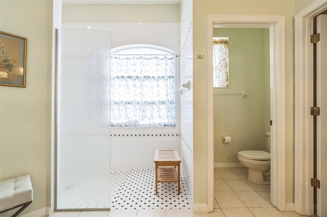 bathroom with tile patterned floors, toilet, and walk in shower