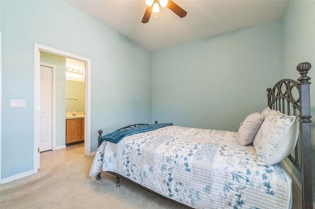 bedroom with light colored carpet, ensuite bath, and ceiling fan