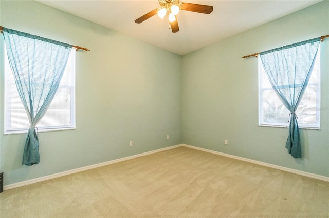 spare room featuring light carpet and ceiling fan