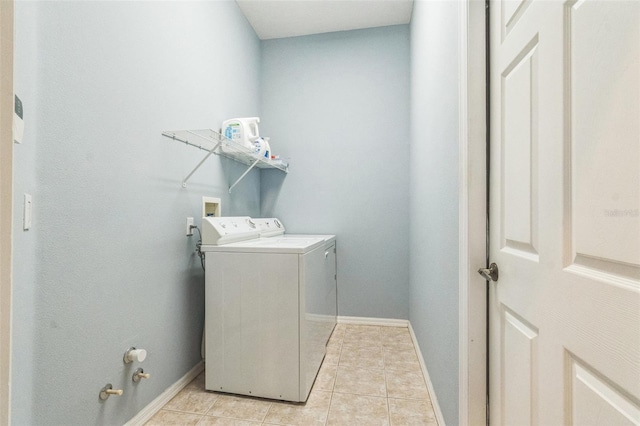 laundry room featuring washer and clothes dryer and light tile patterned floors