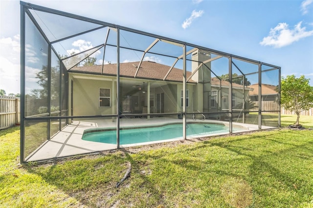 view of pool with a lanai, ceiling fan, a yard, and a patio