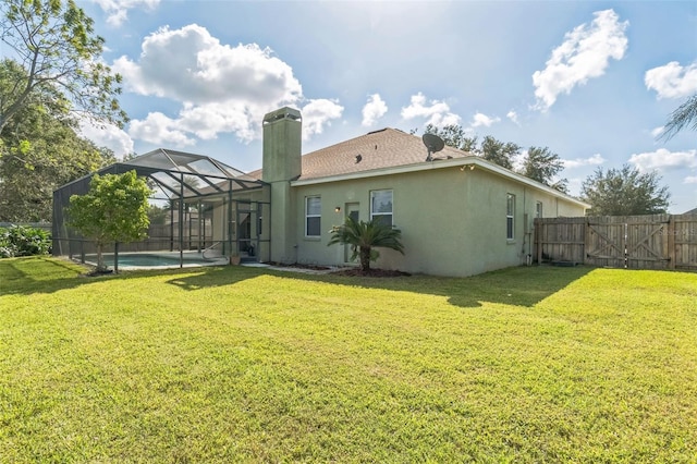 rear view of property featuring a fenced in pool, glass enclosure, and a lawn