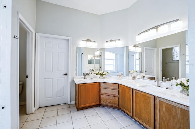 bathroom with toilet, vanity, and tile patterned floors