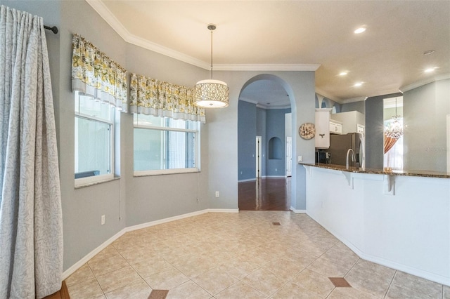 unfurnished dining area featuring crown molding and light tile patterned flooring