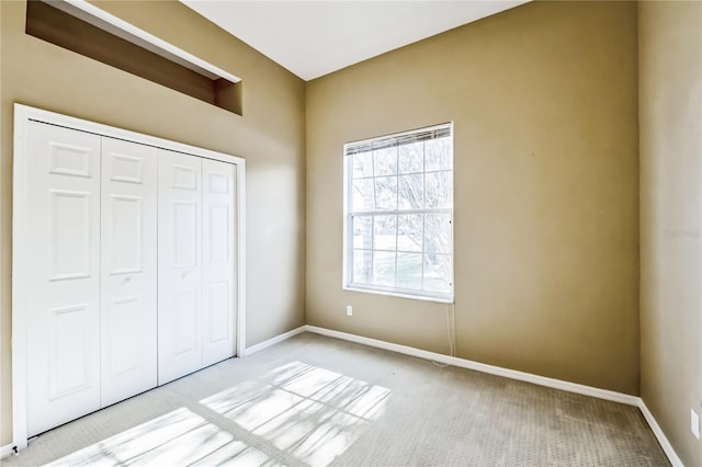 unfurnished bedroom with a closet and light colored carpet