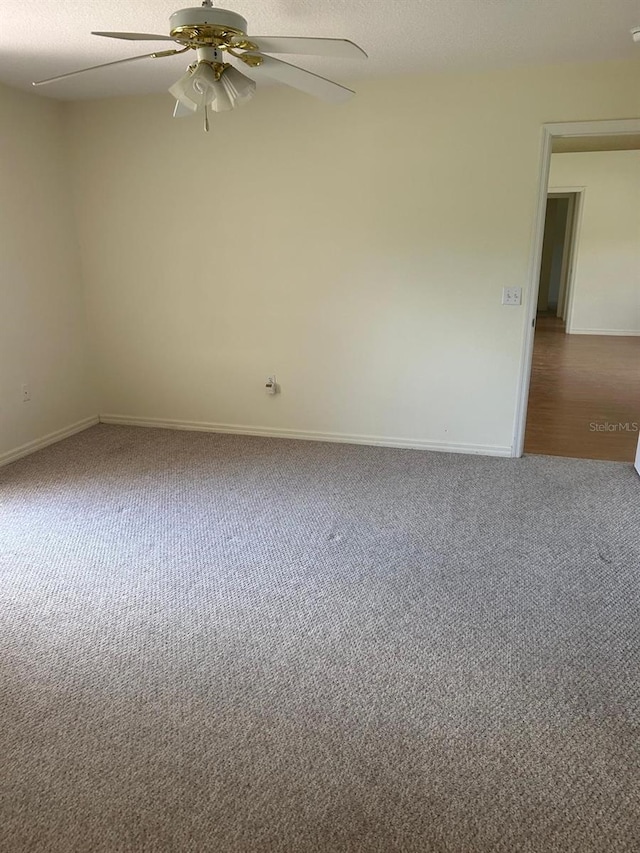 spare room featuring a textured ceiling, carpet floors, and ceiling fan