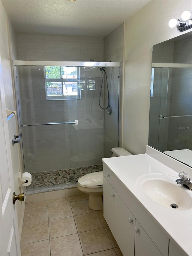 bathroom with vanity, a textured ceiling, toilet, and walk in shower