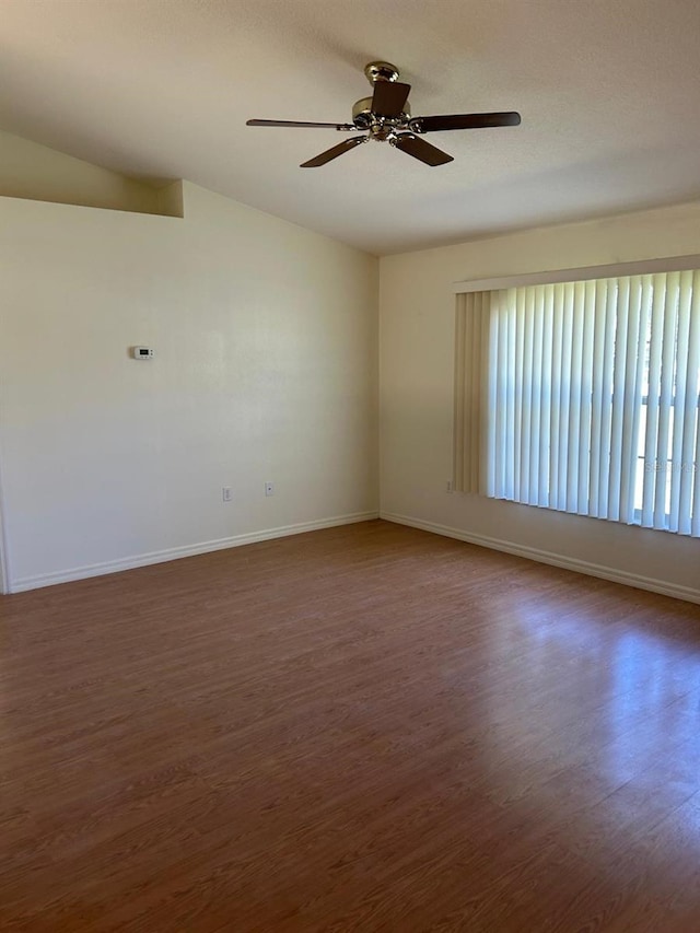 unfurnished room featuring dark wood-type flooring and ceiling fan