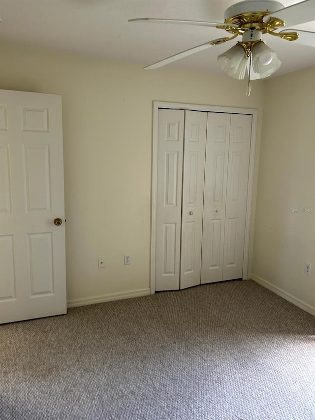 unfurnished bedroom featuring carpet floors, a closet, and ceiling fan