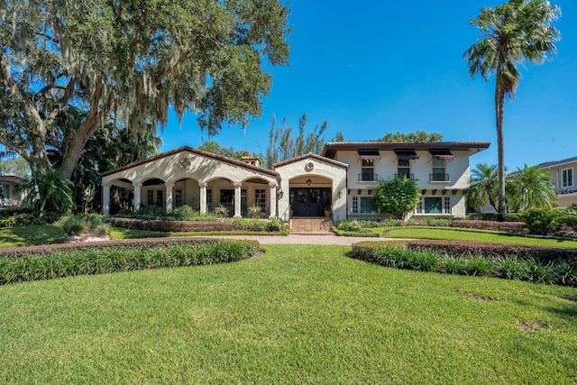 mediterranean / spanish-style house featuring a front lawn