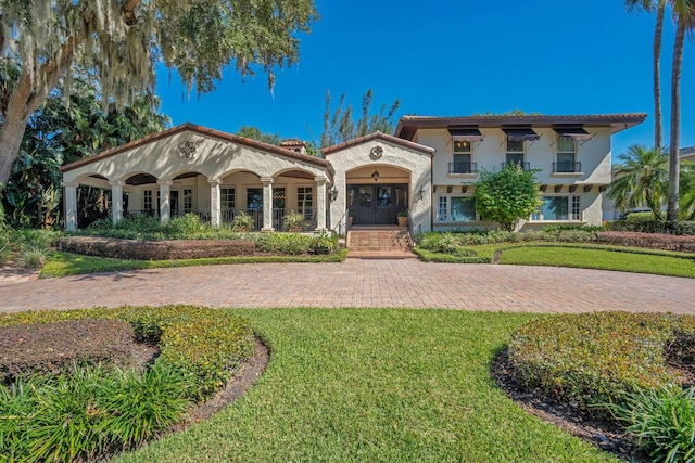 mediterranean / spanish-style home with a front lawn