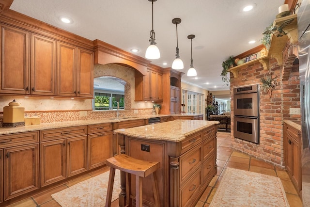 kitchen featuring a kitchen island, double oven, a kitchen breakfast bar, hanging light fixtures, and ornamental molding