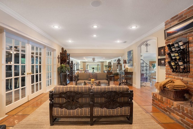 tiled living room featuring crown molding, a textured ceiling, french doors, and ceiling fan