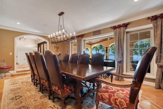 tiled dining space with ornamental molding, a chandelier, and a textured ceiling