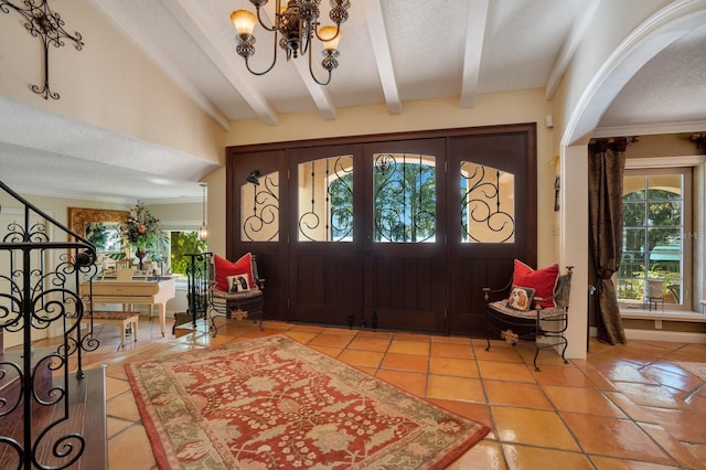 tiled foyer entrance featuring a wealth of natural light, french doors, and a textured ceiling