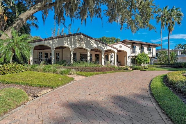 mediterranean / spanish-style home with covered porch