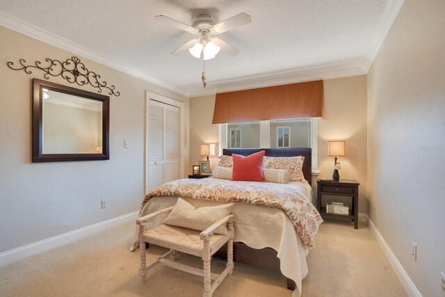 bedroom with a closet, ornamental molding, light colored carpet, and ceiling fan