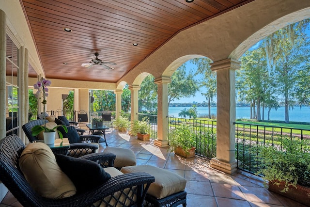 view of patio / terrace featuring a water view and ceiling fan