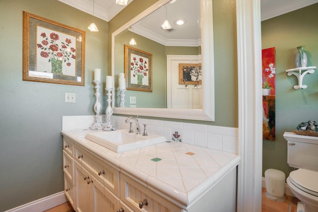 bathroom with vanity, ornamental molding, backsplash, and toilet