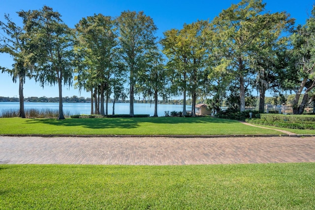 surrounding community featuring a lawn and a water view